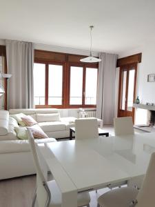 een witte woonkamer met een witte tafel en stoelen bij Fabulous view on the Lake in Valsolda