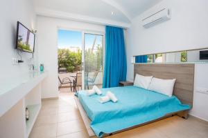 a bedroom with a blue bed and a balcony at Stay Helios in Faliraki