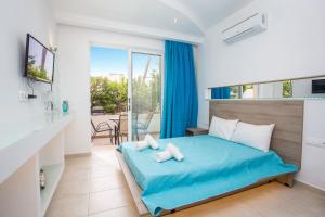 een slaapkamer met een blauw bed en een balkon bij Stay Helios in Faliraki