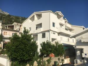 un gran edificio blanco con árboles delante de él en Apartments Marika, en Drasnice