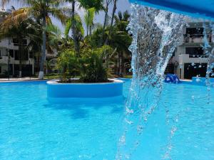a water fountain in a swimming pool with palm trees at Hotel Green 16 in Cancún