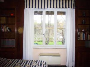- une fenêtre avec des rideaux blancs dans la chambre dans l'établissement B&B Red Horse, à Pise
