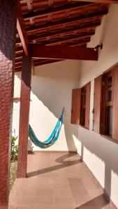 a porch with a hammock in a house at Quarto para uma pessoa com banheiro exclusivo in Alfenas