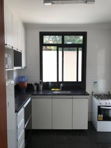 uma cozinha branca com um lavatório e uma janela em Locking's San Diego em Belo Horizonte