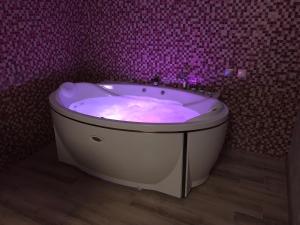 モスクワにあるHotel Chasy Leskovaのバスルーム(紫色の照明が付いたバスタブ付)