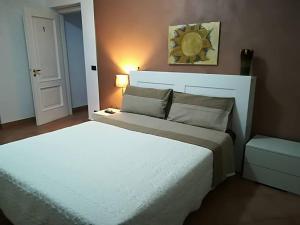 Un dormitorio con una gran cama blanca y una lámpara en Le ginestre, en Caselle Torinese
