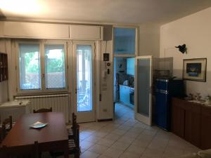 uma cozinha e sala de jantar com uma mesa e um frigorífico em Casa Viareggio em Viareggio