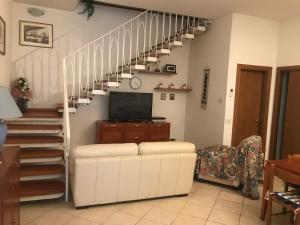 uma sala de estar com uma escada com um sofá e uma televisão em Casa Viareggio em Viareggio