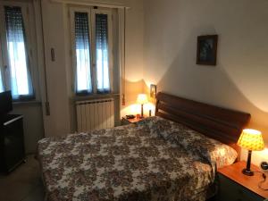 a bedroom with a bed and two lamps and windows at Casa Viareggio in Viareggio