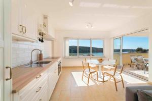 a kitchen and dining room with a table and chairs at Sunset House in Rab
