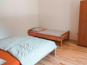 twee bedden in een kleine kamer met houten vloeren bij Apartments Yvonne in Pakoštane