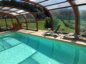 a swimming pool with two chairs in a house at Holiday home Le clos du phare in Saint-Samson-de-la-Roque