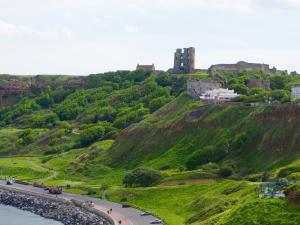 a castle on top of a hill with a road at Boston Hotel in Scarborough