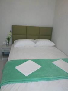 a bed with a green and white blanket on it at Milla Lux 2 in Paralia Katerinis