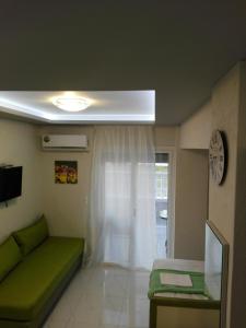 a living room with a green couch and a window at Milla Lux 2 in Paralia Katerinis