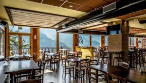a restaurant with tables and chairs and mountains in the background at Bilocale Fronte Piste - Appartamentiflarida Sansicario Alto in San Sicario
