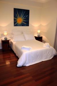 una camera da letto con un grande letto bianco con due lampade di Porto Patricio Apartments a Porto