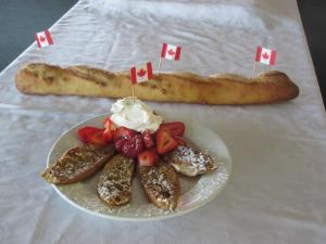 a plate of food with strawberries and a piece of bread at Red Top Motor Inn in Iron Bridge