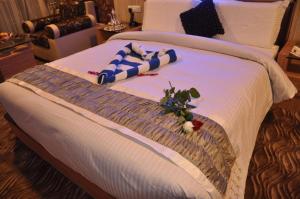 a bed in a hotel room with flowers on it at Astoria Residency in Ooty