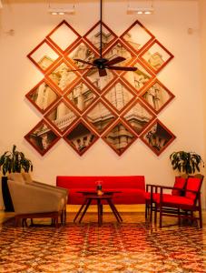 a living room with a red couch and a table at Merida Santiago Hotel Boutique in Mérida