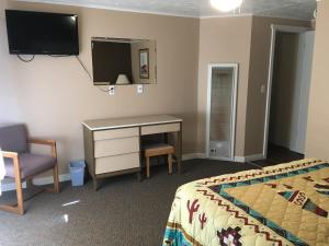 a bedroom with a bed and a desk and a chair at Sun -N- Sand Motel in Kanab