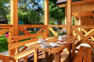 a wooden deck with a wooden table with books at ALKADO Jastrzebia Gora in Jastrzębia Góra +7 photos