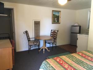 a hotel room with a table and chairs and a kitchen at Sun -N- Sand Motel in Kanab