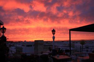 un tramonto su una città con due lampioni di AL - Alojamento Local Pension Bicuar a Olhão Altre 69 foto