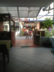 a patio with tables and chairs in a restaurant at Pension Zum Ross in Karon Beach