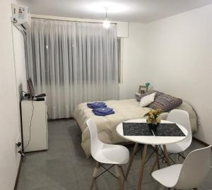 1 dormitorio con 1 cama, mesa y sillas en Apartamento La Mansa en Córdoba