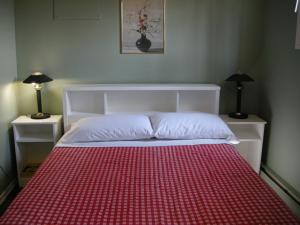 um quarto com uma cama com um cobertor vermelho em Birch Haven by the Beach em Wasaga Beach