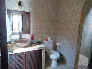 a bathroom with a sink and a toilet and a mirror at Apa Kabar Villas in Amed