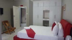 een slaapkamer met een bed en een stoel erin bij TINTECH BED & BREAKFAST in Francistown +24 foto's