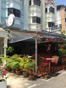 a patio with chairs and plants in front of a building at Pension Zum Ross in Karon Beach