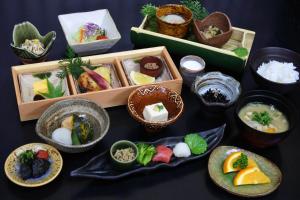 una mesa con platos de comida y tazones de comida en Kurokawa Onsen Yama no Yado Shinmeikan, en Minamioguni