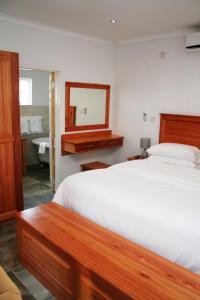 a bedroom with a bed and a mirror and a sink at Serowe Hotel in Serowe