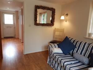 a living room with a couch and a mirror at The Beekeeper's Cottage in Saint Columb Major