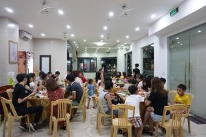 a group of people sitting at tables in a restaurant at Thanh Tu Hotel in Cửa Lô