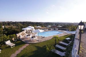 an overhead view of a pool with chairs and umbrellas at B&B Le Colline Country House in Anguillara Sabazia