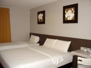 a hotel room with two beds and two pictures on the wall at Alor Boutique Hotel Sdn Bhd in Kuala Lumpur +13 photos