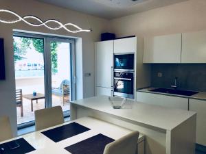 a kitchen with white cabinets and a table with chairs at Apartments & rooms Artemus Belveder in Koper
