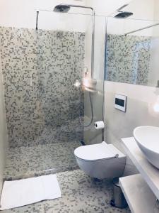 uma casa de banho com um chuveiro, um WC e um lavatório. em Apartments & rooms Artemus Belveder em Koper