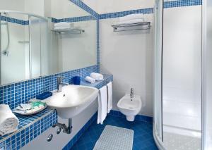 カットーリカにあるHotel Brigの青いタイル張りのバスルーム(洗面台、トイレ付)