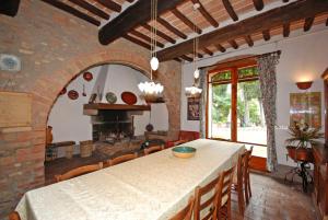 een keuken met een tafel met stoelen en een open haard bij Villa Remignoli in San Gimignano