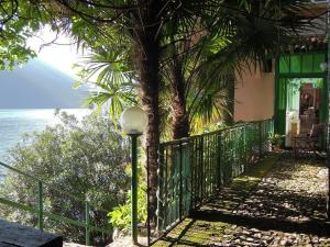a street light next to a house with a tree at Charming house with the private dock I in Argegno +14 photos