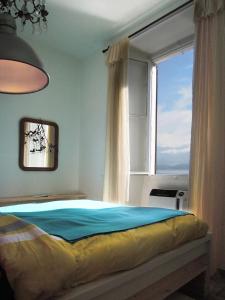 a bedroom with a bed with a large window at Charming house with the private dock I in Argegno