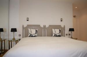 1 dormitorio con 1 cama blanca grande y 2 almohadas en Logis Hotel L'europe, en Pontivy