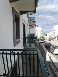 einen Balkon eines Gebäudes mit Autos, die auf einer Straße geparkt sind in der Unterkunft Borgo Antico in Peschici