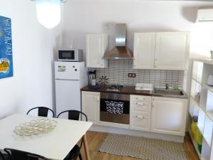 a kitchen with white cabinets and a table and a sink at can jaume portas in Sant Francesc Xavier
