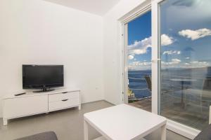 a living room with a tv and a large window at Apartment Botta in Mimice